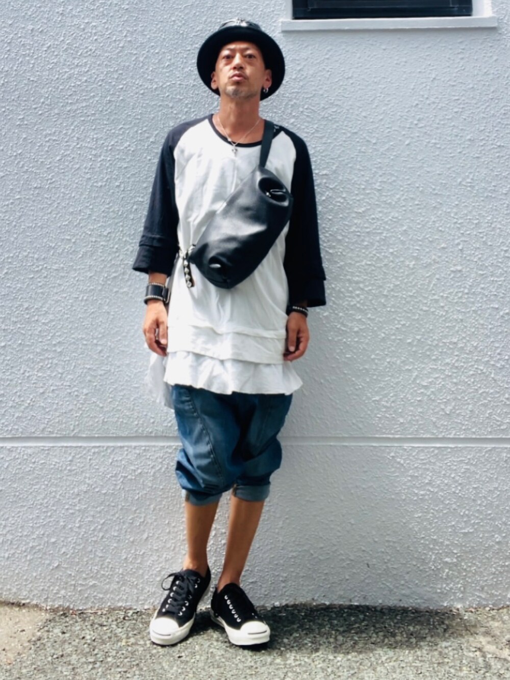 ブルー系のデニムパンツ、ブラック系のスニーカー、ブラック系のショルダーバッグを着用したメンズの夏コーディネートの3枚目の写真