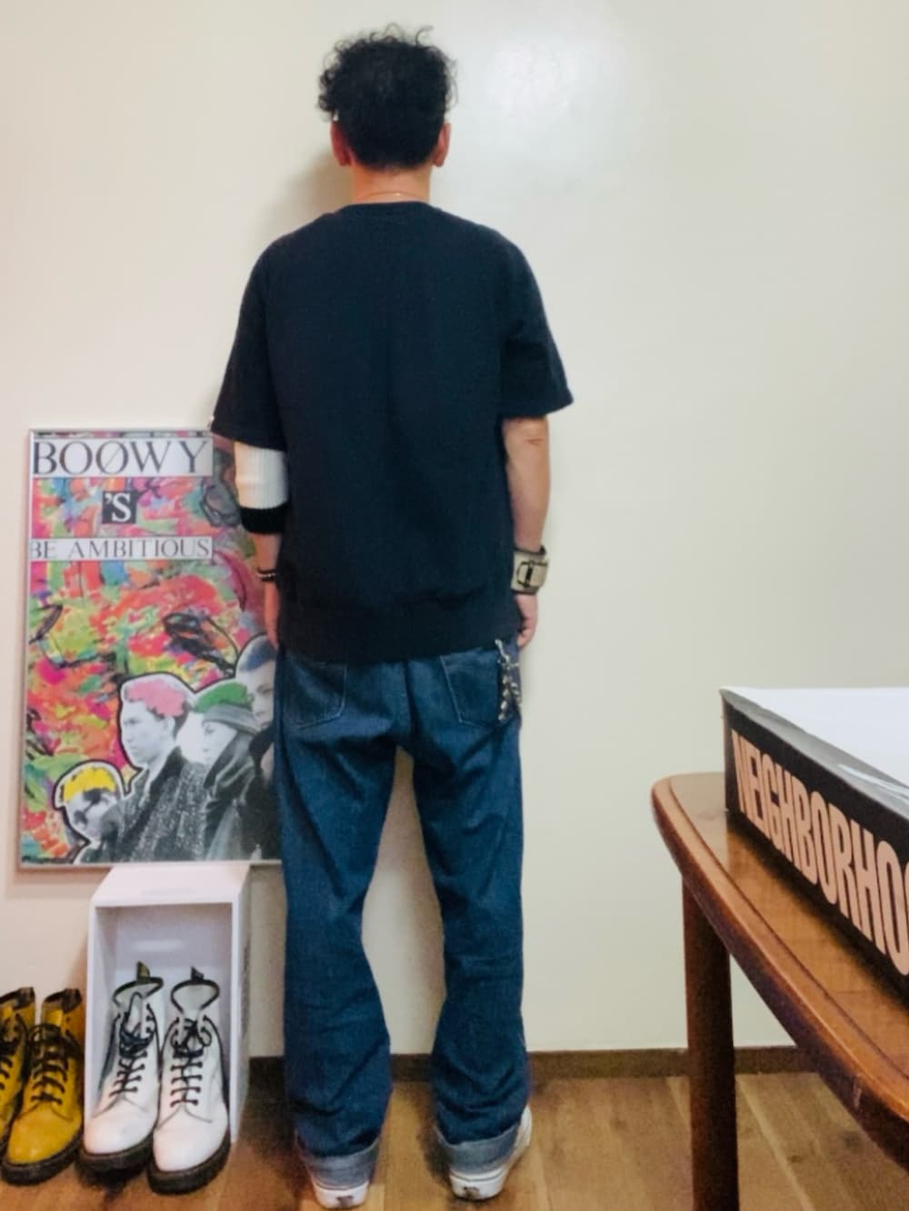 ブラック系のスウェット、ブルー系のデニムパンツ、ホワイト系のスニーカーを着用したメンズの秋コーディネートの3枚目の写真