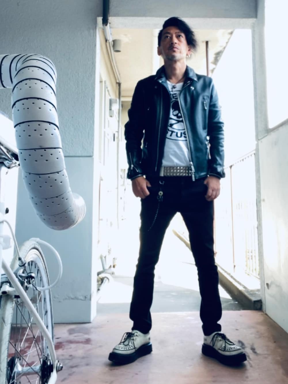 ブラック系のライダースジャケット、ホワイト系のTシャツ/カットソー、ブラック系のパンツを着用したメンズの秋コーディネートの2枚目の写真