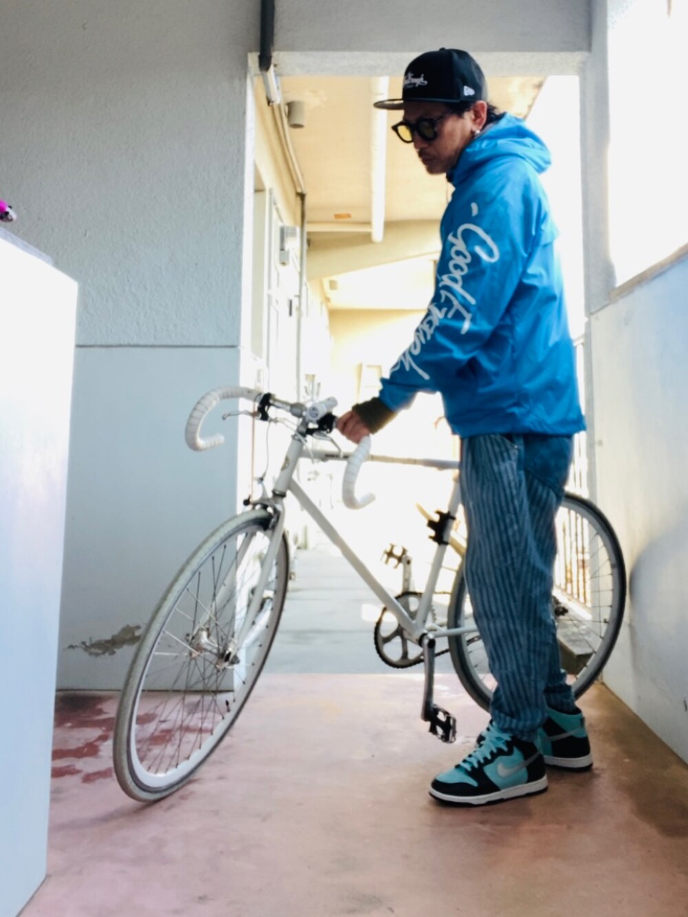 ブルー系のナイロンジャケット、ブルー系のデニムパンツ、グリーン系のスニーカーを着用したメンズの冬コーディネートの5枚目の写真