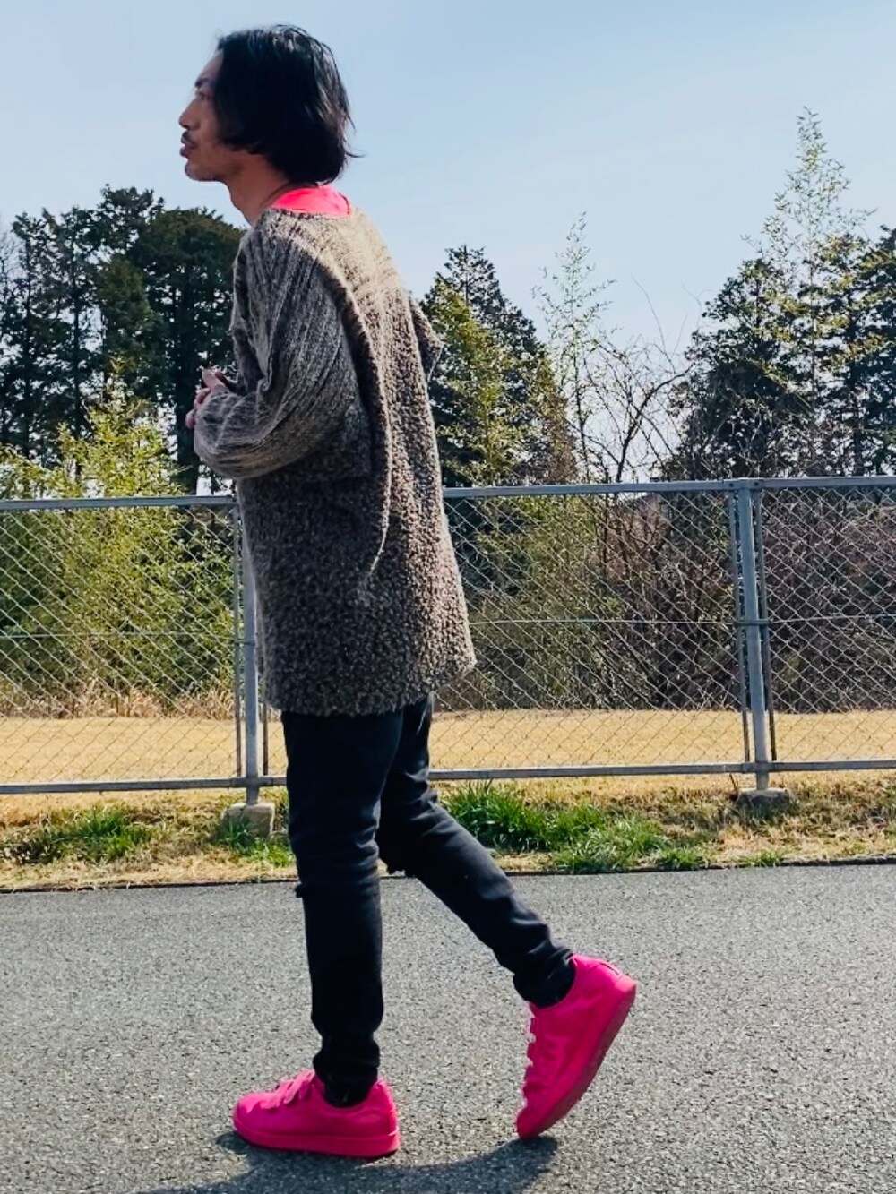 ブラウン系のニット/セーター、ピンク系のTシャツ/カットソー、ブラック系のデニムパンツを着用したメンズの春コーディネートの4枚目の写真