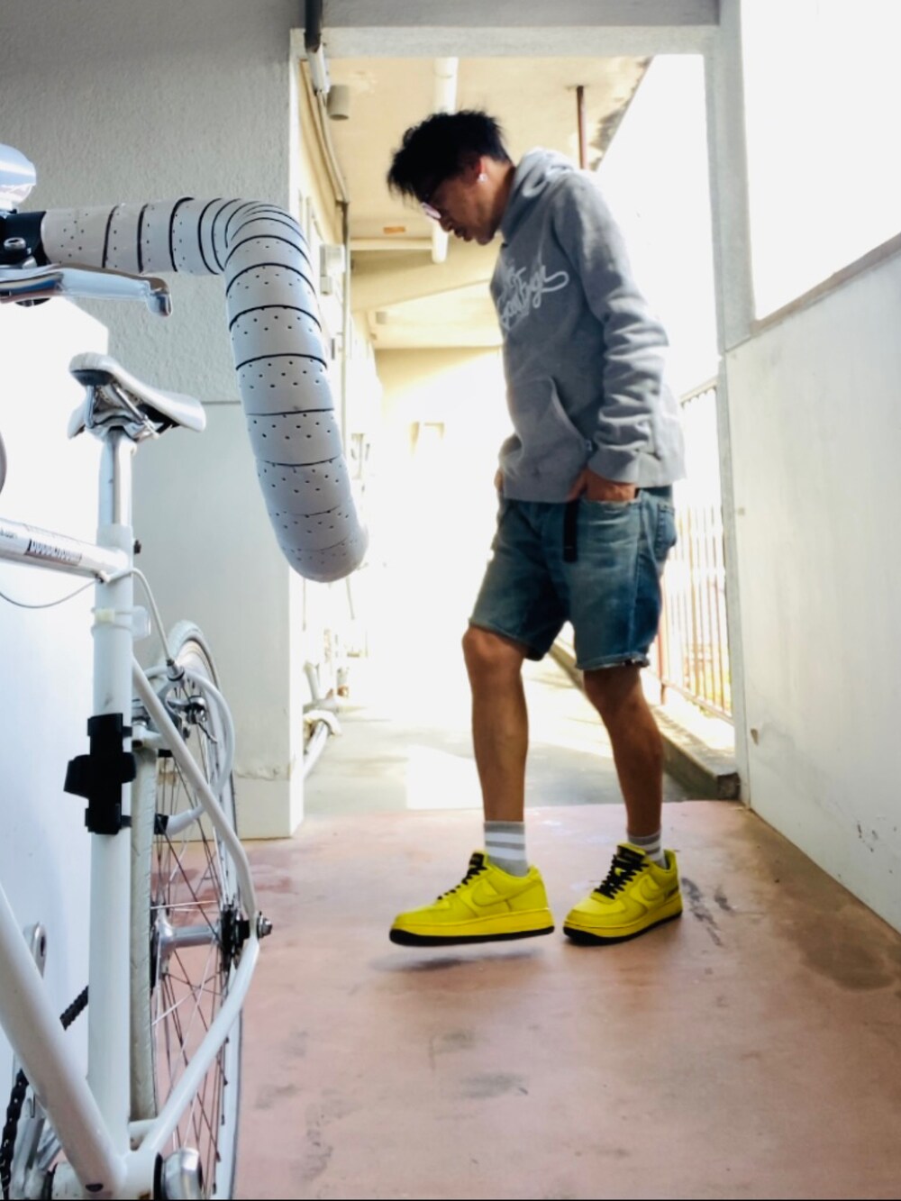 グレー系のパーカー、ブルー系のその他パンツ、イエロー系のスニーカーを着用したメンズの秋コーディネートの3枚目の写真