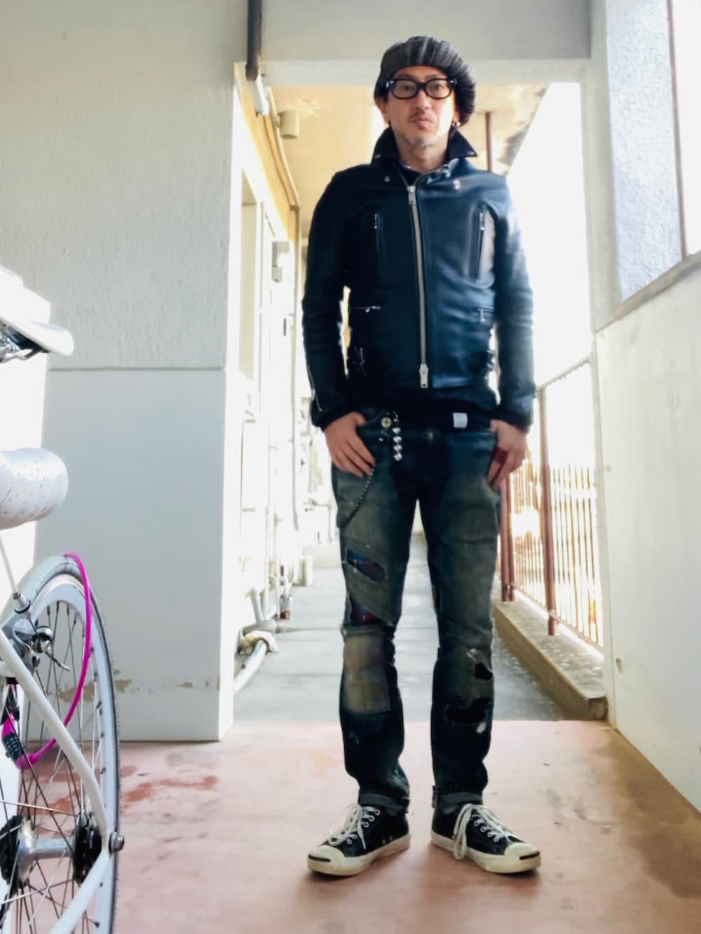 ブルー系のデニムパンツ、ブラック系のライダースジャケット、ブラック系のニット/セーターを着用したメンズの冬コーディネートの2枚目の写真