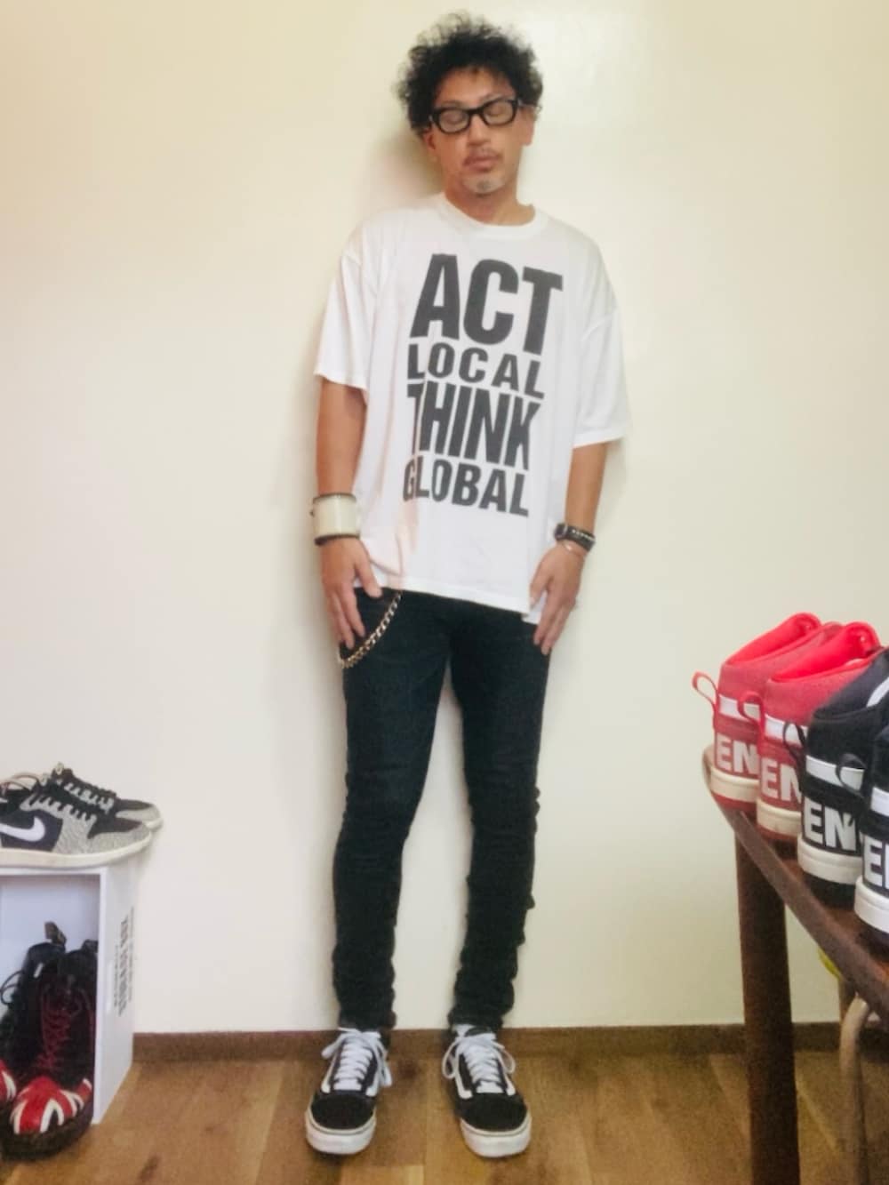 ブラック系のデニムパンツ、ブラック系のスニーカー、ホワイト系のTシャツ/カットソーを着用したメンズの秋コーディネートの2枚目の写真