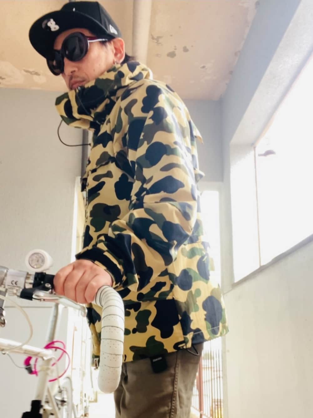 イエロー系のマウンテンパーカー、グリーン系のカーゴパンツ、ブラック系のブーツを着用したメンズの秋コーディネートの2枚目の写真