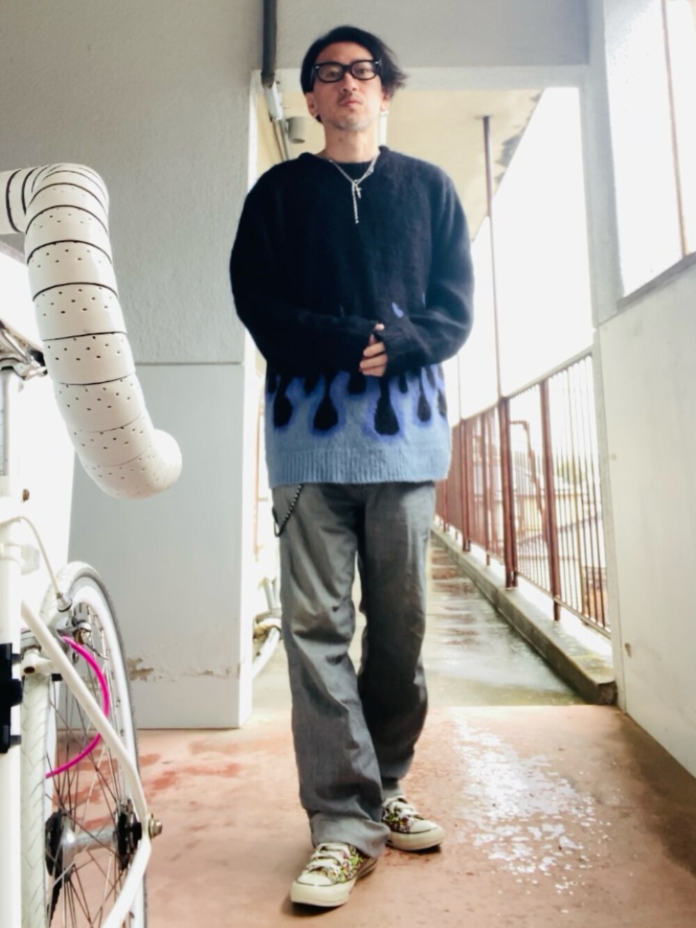 ブラック系のニット/セーター、グレー系のデニムパンツ、その他のスニーカーを着用したメンズの春コーディネートの5枚目の写真