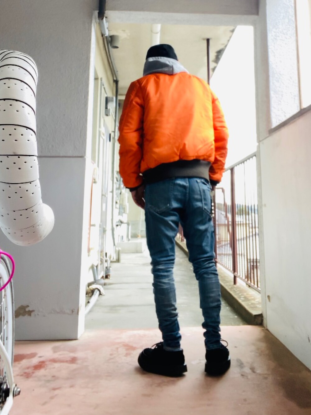 グレー系のパーカー、グレー系のMA-1、ブルー系のデニムパンツを着用したメンズの冬コーディネートの5枚目の写真