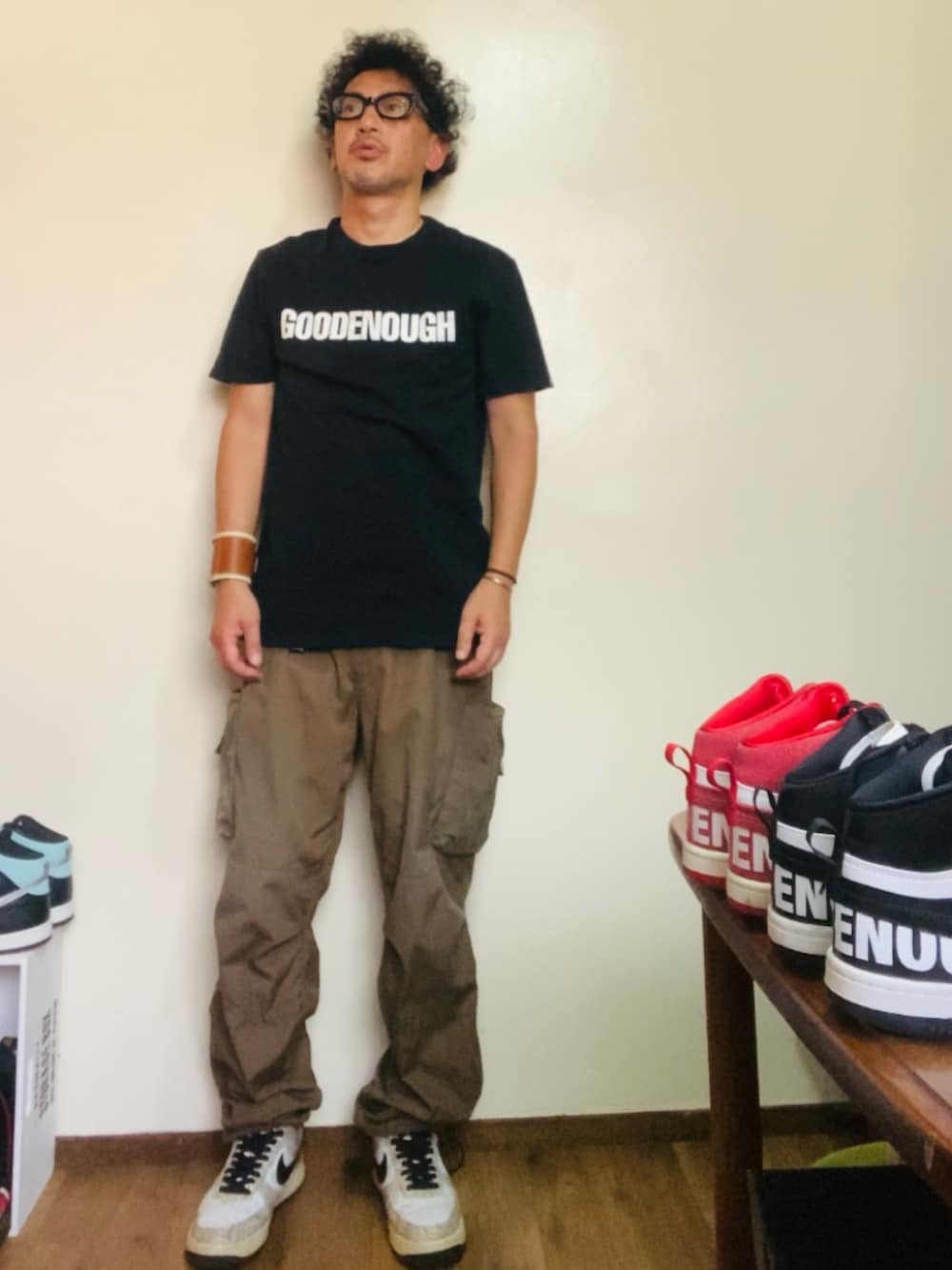 ブラック系のTシャツ/カットソー、ブラウン系のカーゴパンツ、ベージュ系のスニーカーを着用したメンズの秋コーディネートの2枚目の写真