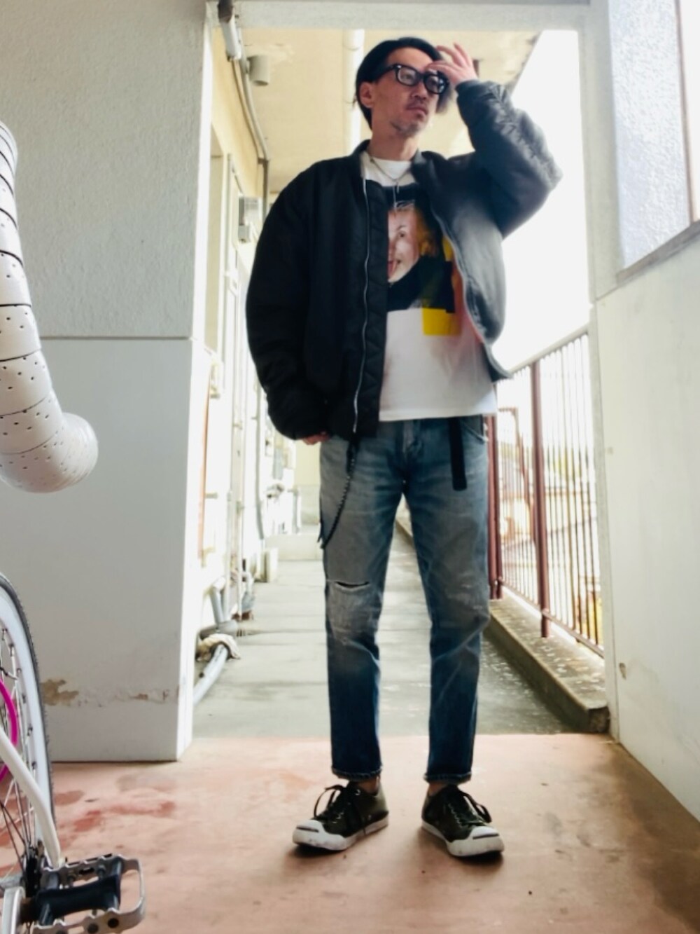 グレー系のMA-1、ホワイト系のTシャツ/カットソー、ブルー系のデニムパンツを着用したメンズの春コーディネートの3枚目の写真