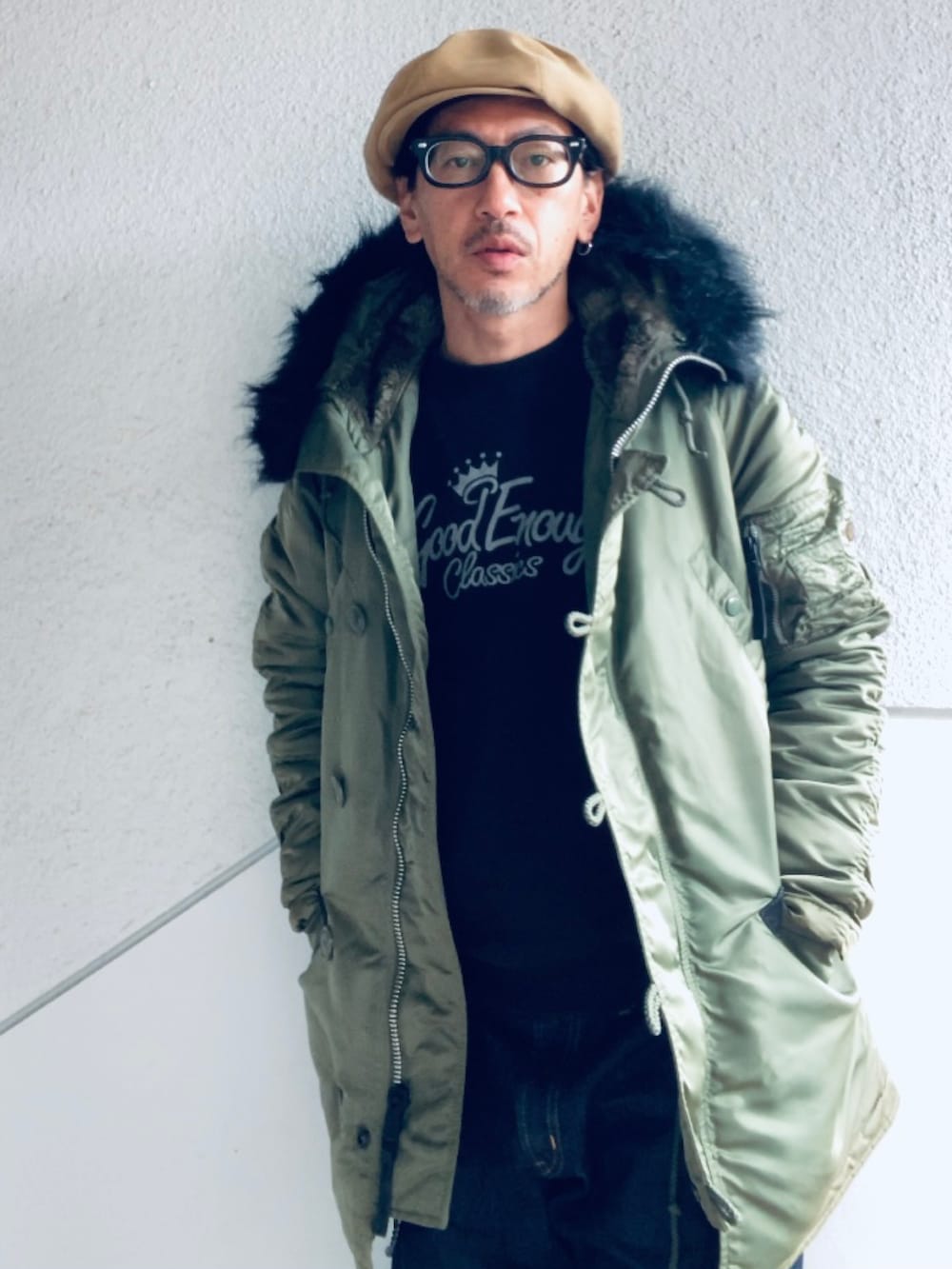 グリーン系のミリタリージャケット、ブラック系のスウェット、ブルー系のデニムパンツを着用したメンズの冬コーディネートの4枚目の写真