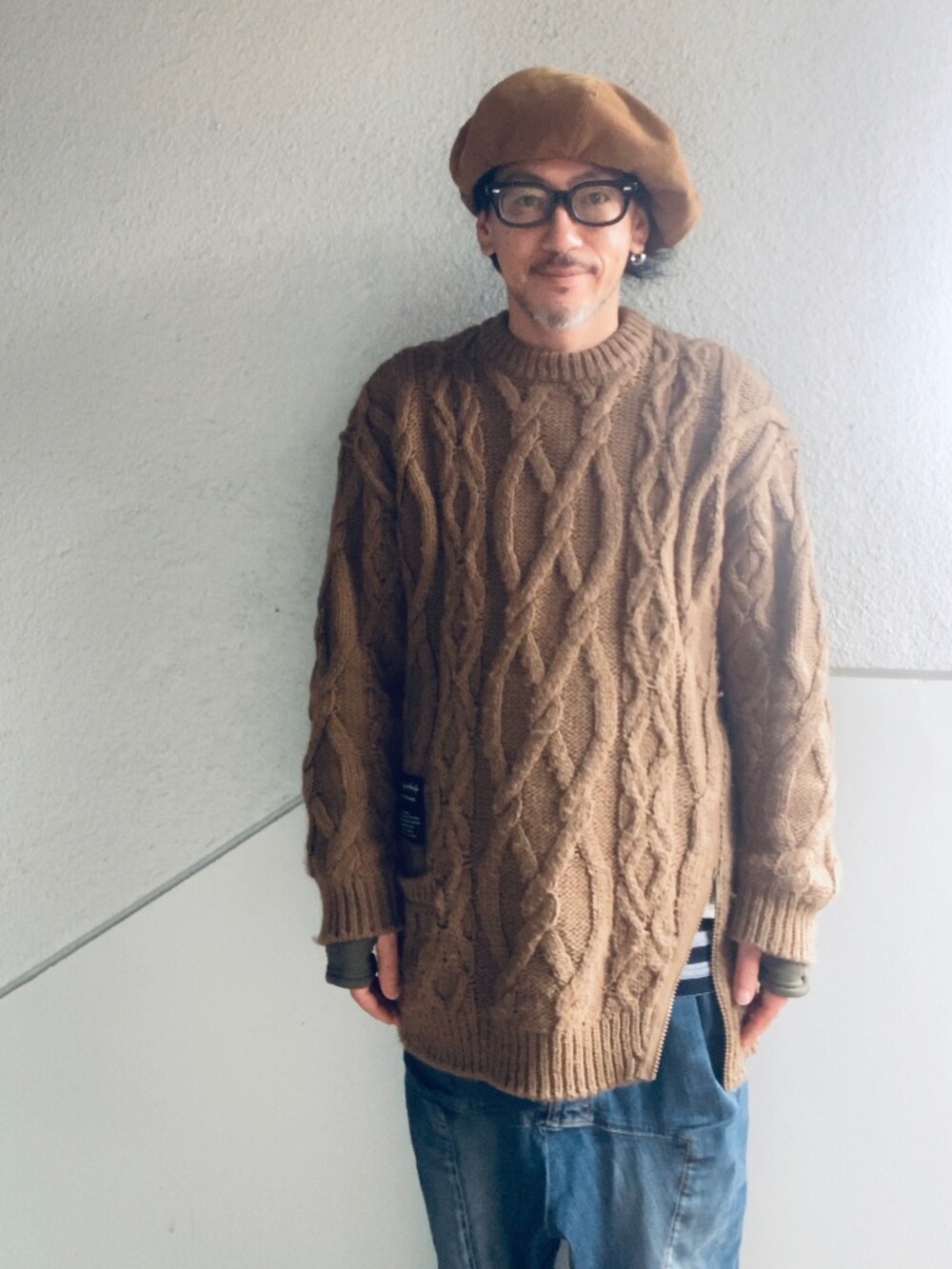 ブラウン系のニット/セーター、ブルー系のデニムパンツ、ベージュ系のブーツを着用したメンズの冬コーディネートの2枚目の写真