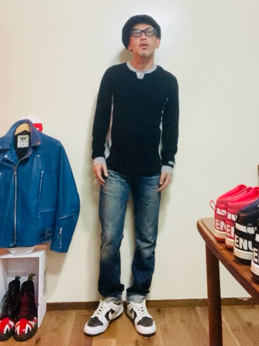 ブラック系のTシャツ/カットソー、ブルー系のデニムパンツ、ホワイト系のスニーカーを着用したメンズの秋コーディネートの2枚目の写真
