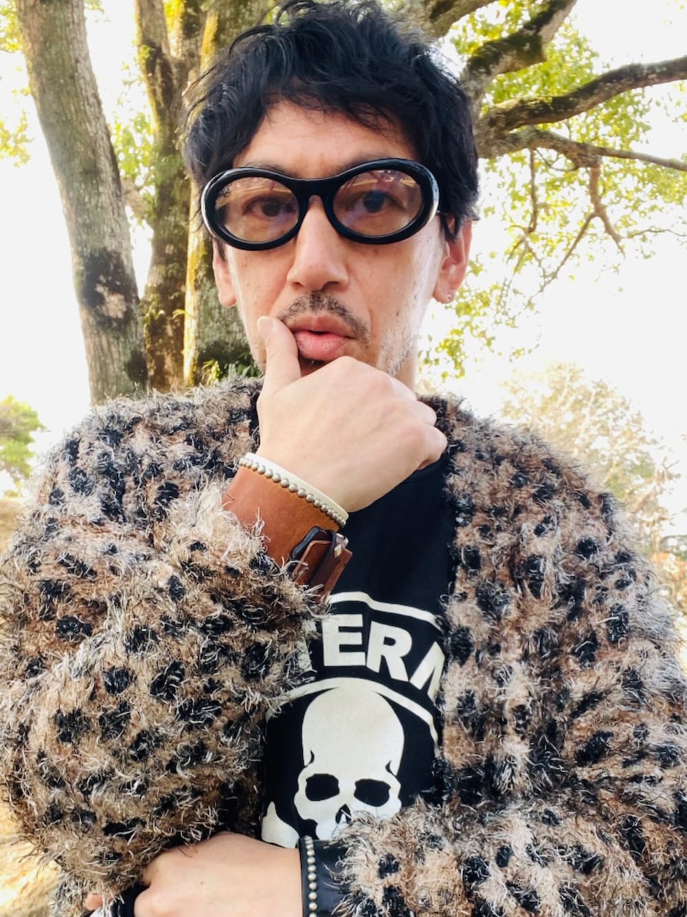 ブラウン系のカーディガン/ボレロ、ブラック系のTシャツ/カットソー、ブラック系のデニムパンツを着用したメンズの春コーディネートの2枚目の写真