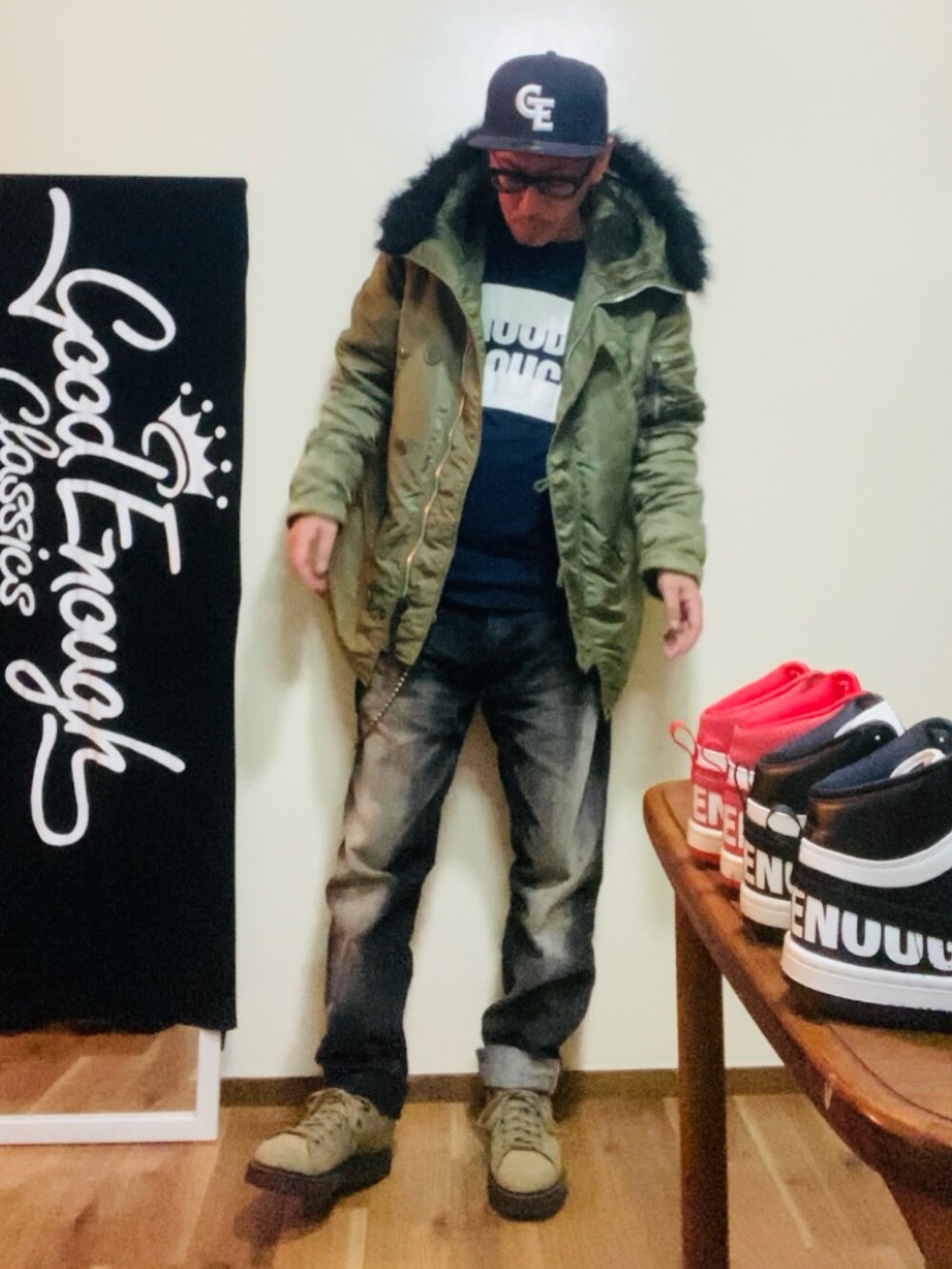 ブルー系のTシャツ/カットソー、グリーン系のミリタリージャケット、ブラック系のデニムパンツを着用したメンズの秋コーディネートの2枚目の写真