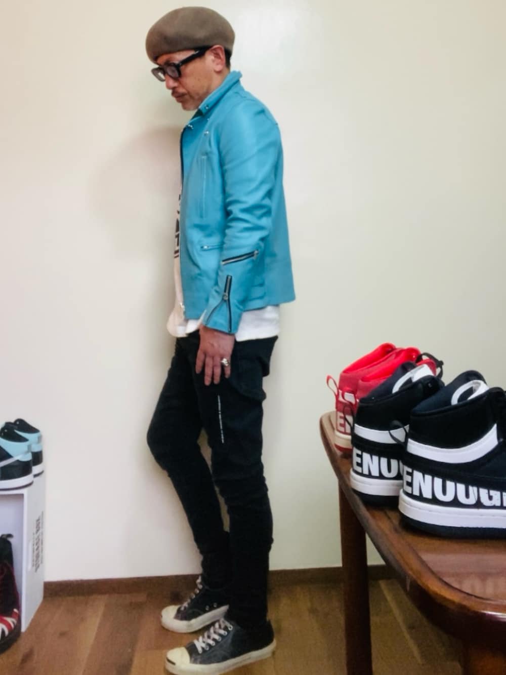 ブルー系のライダースジャケット、ブラック系のデニムパンツ、ブラック系のスニーカーを着用したメンズの春コーディネートの2枚目の写真