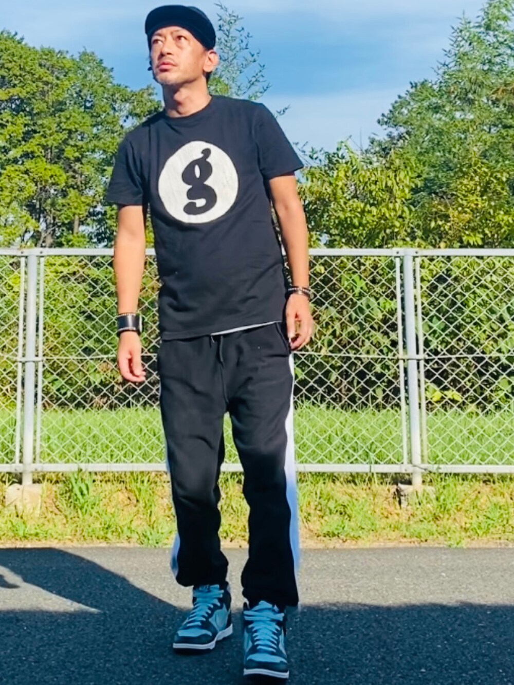 ブラック系のTシャツ/カットソー、ブラック系のスウェットパンツ、グリーン系のスニーカーを着用したメンズの秋コーディネートの3枚目の写真