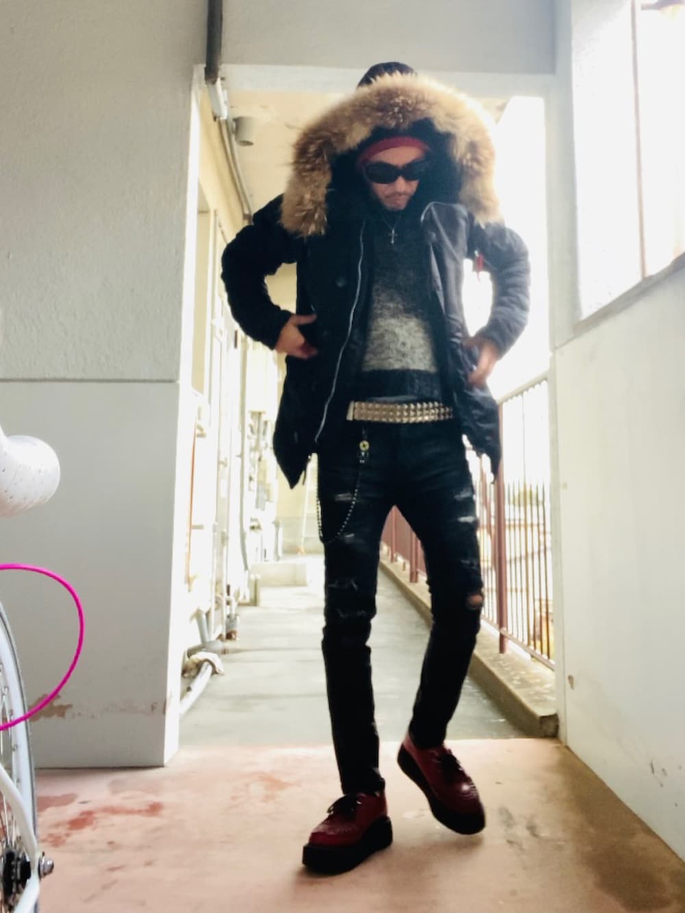 ブラック系のミリタリージャケット、ブラック系のニット/セーター、ブラック系のデニムパンツを着用したメンズの冬コーディネートの5枚目の写真