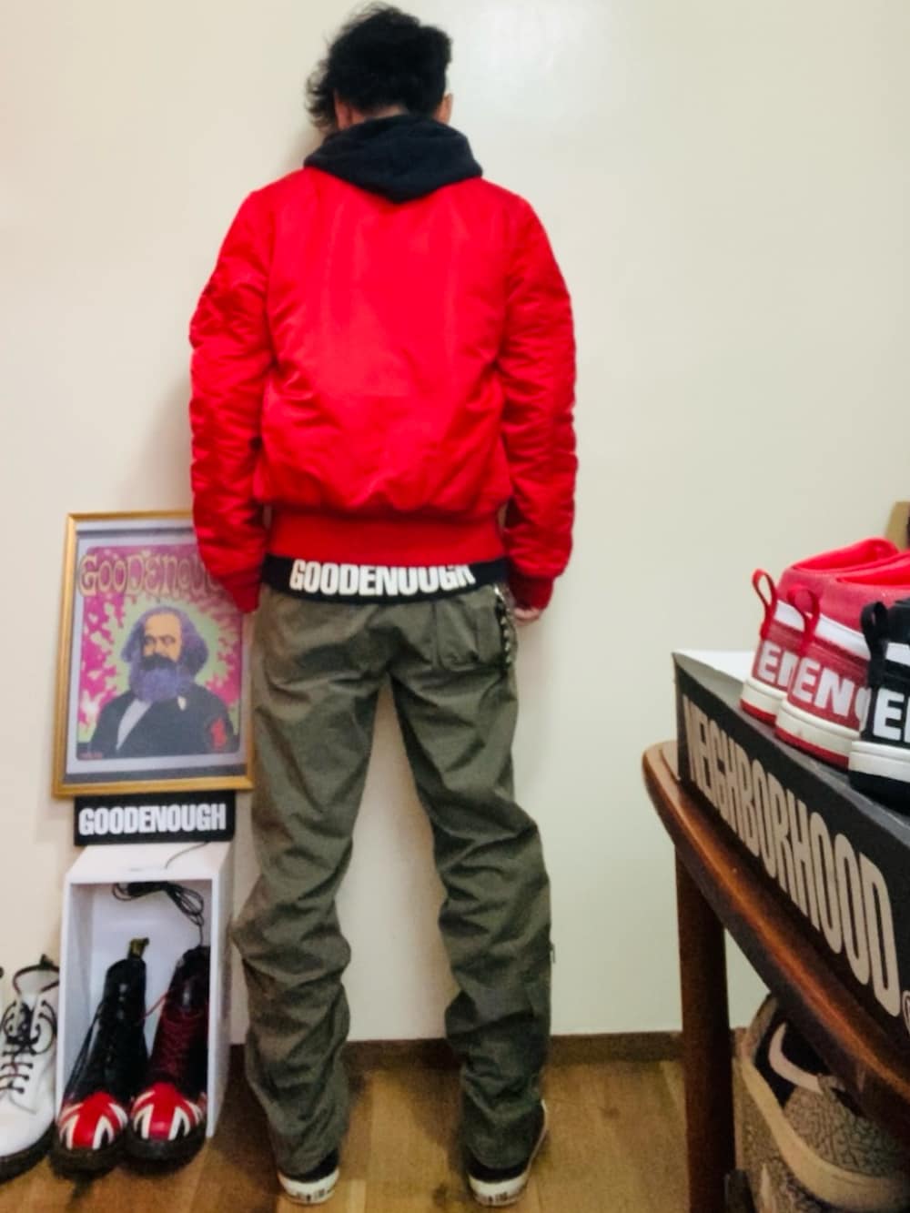 ブラック系のパーカー、レッド系のMA-1、グリーン系のカーゴパンツを着用したメンズの春コーディネートの2枚目の写真