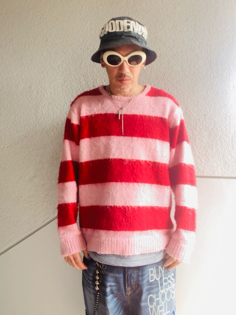 ブルー系のデニムパンツ、ピンク系のニット/セーター、ピンク系のスニーカーを着用したメンズの春コーディネートの2枚目の写真