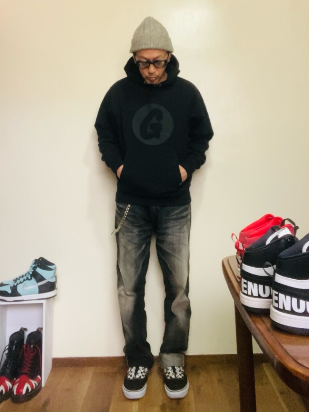 ブラック系のパーカー、ブラック系のデニムパンツ、ブラック系のスニーカーを着用したメンズの春コーディネートの2枚目の写真