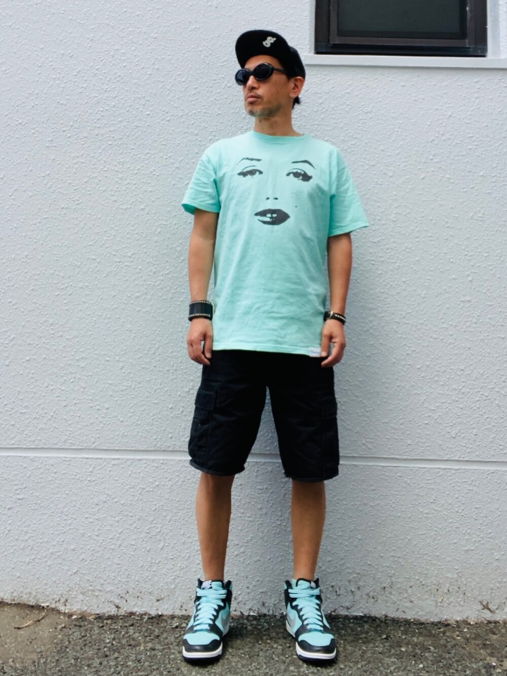 ブルー系のTシャツ/カットソー、ブラック系のカーゴパンツ、グリーン系のスニーカーを着用したメンズの春コーディネートの5枚目の写真