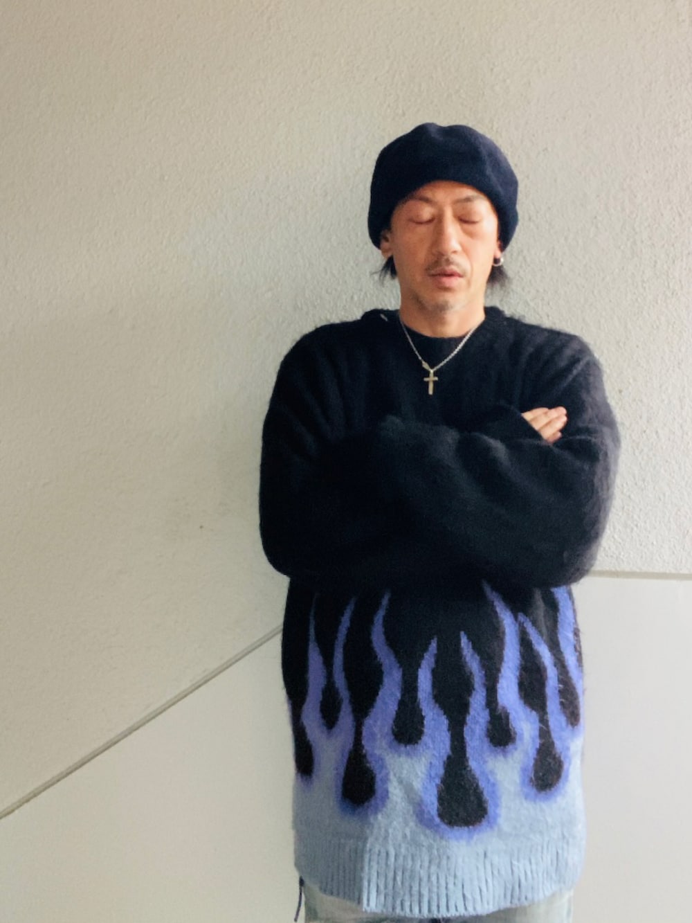 ブラック系のニット/セーター、ブルー系のデニムパンツ、ブラック系のブーツを着用したメンズの冬コーディネートの2枚目の写真
