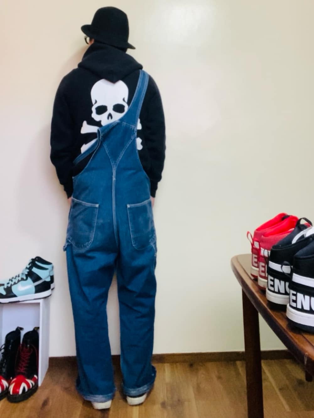 ブラック系のパーカー、ブルー系のサロペット/オーバーオール、ブラック系のスニーカーを着用したメンズの春コーディネートの4枚目の写真