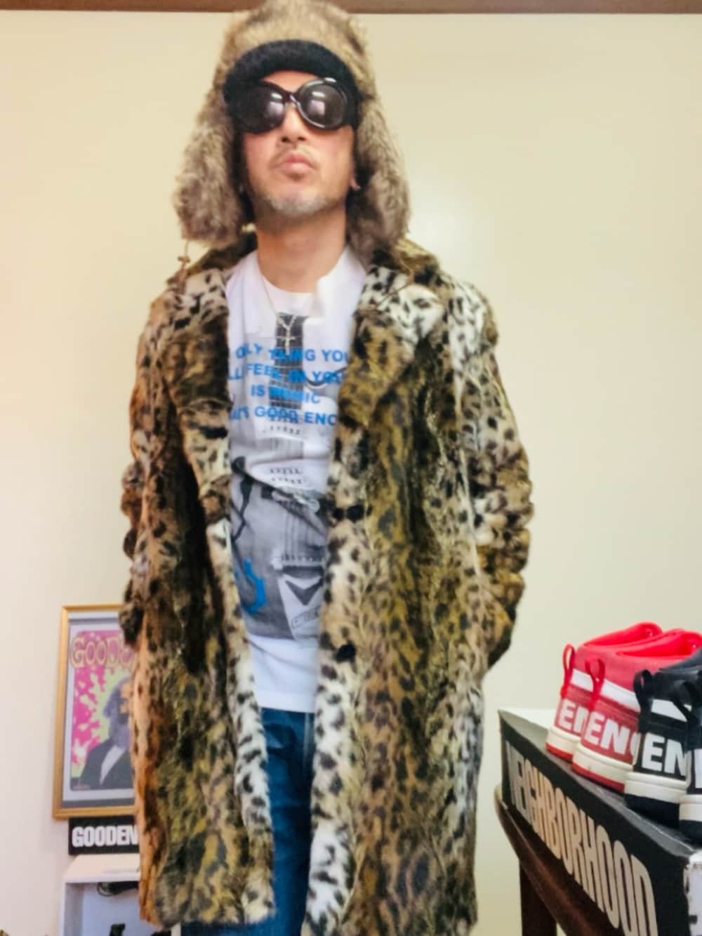 ブラウン系のムートンコート、ホワイト系のTシャツ/カットソー、ブルー系のデニムパンツを着用したメンズの冬コーディネートの4枚目の写真