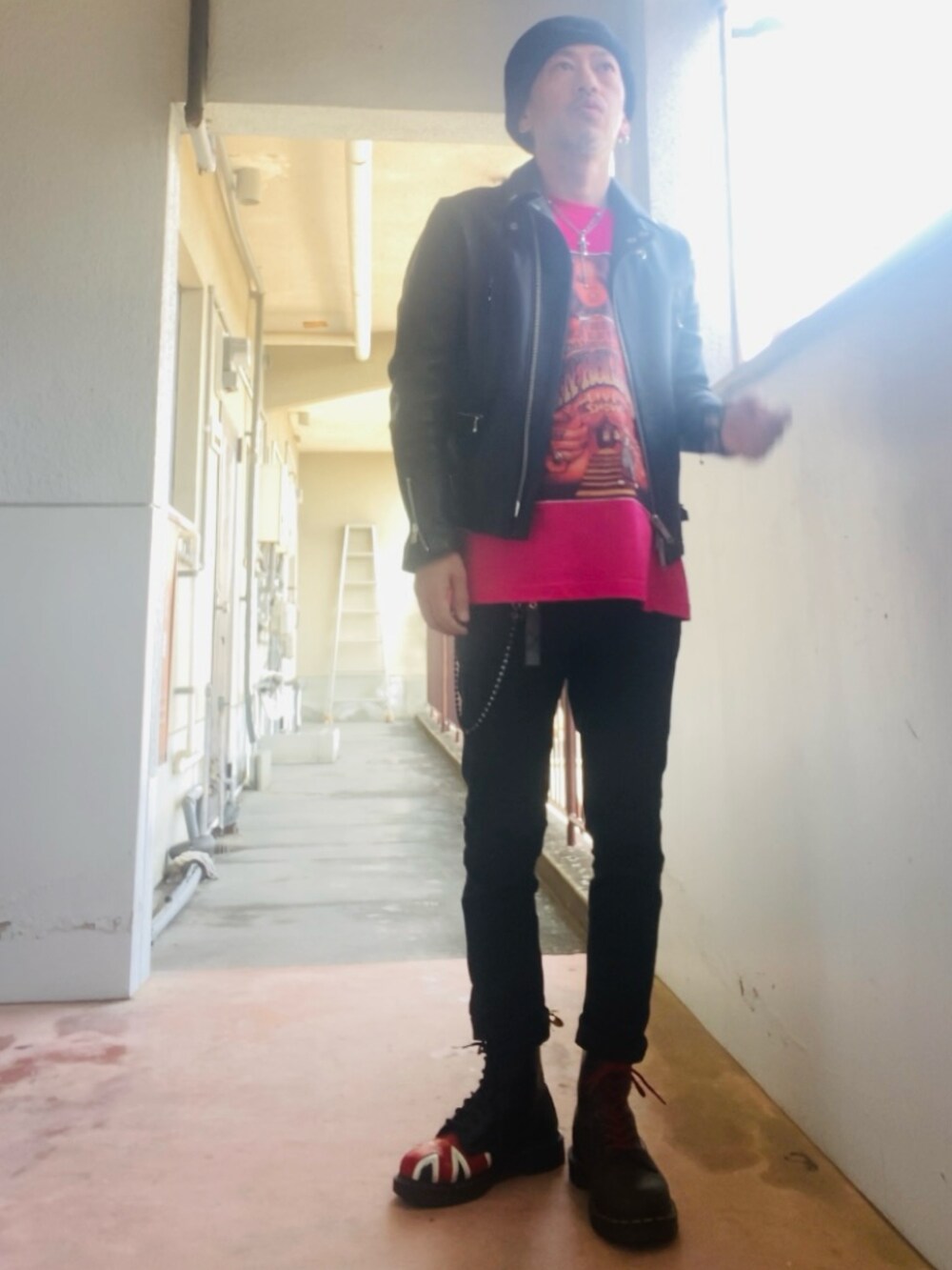 ピンク系のTシャツ/カットソー、ブラック系のライダースジャケット、ブラック系のパンツを着用したメンズの春コーディネートの4枚目の写真