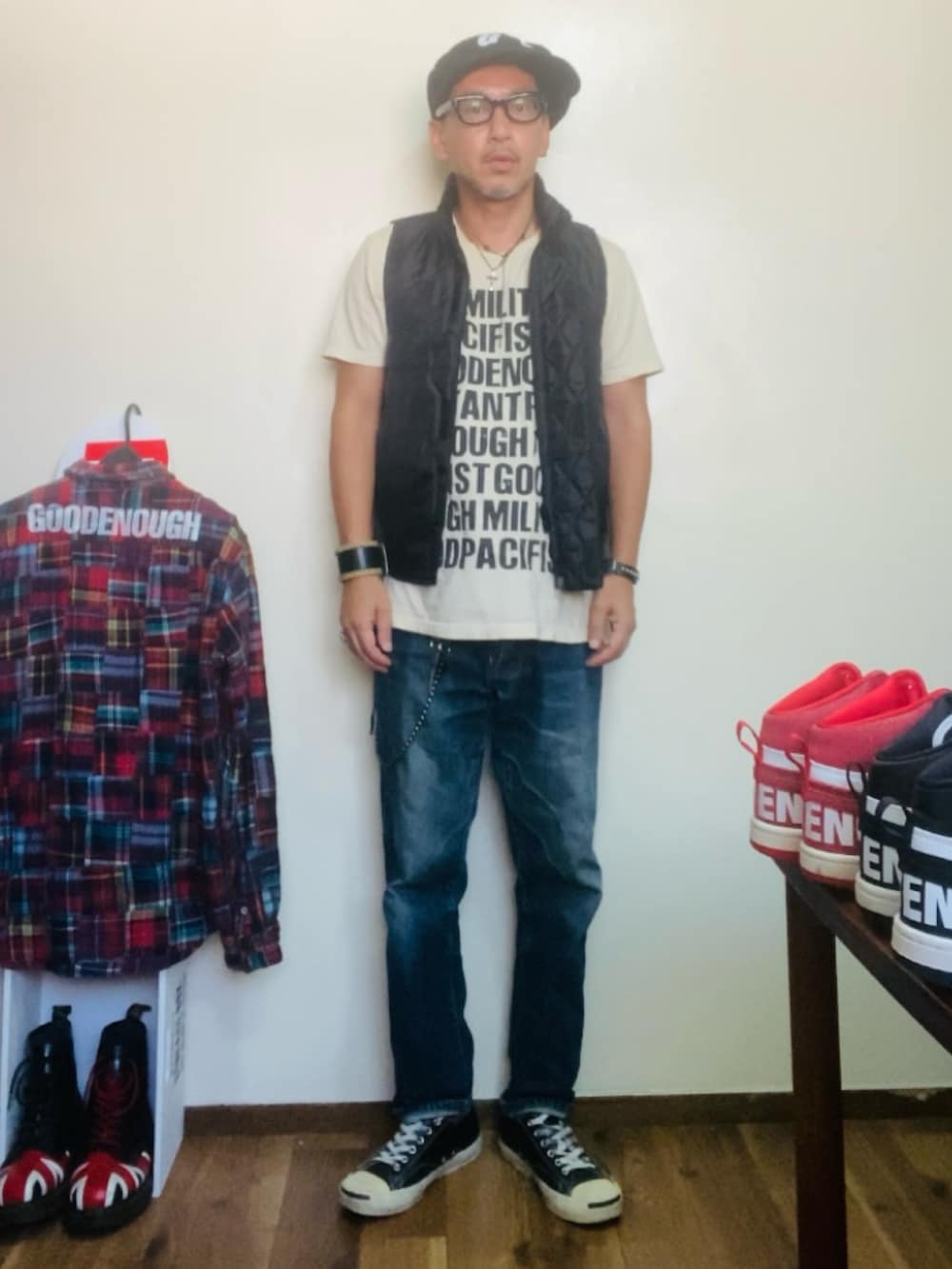 ベージュ系のTシャツ/カットソー、ブラック系のベスト、ブルー系のデニムパンツを着用したメンズの秋コーディネートの3枚目の写真