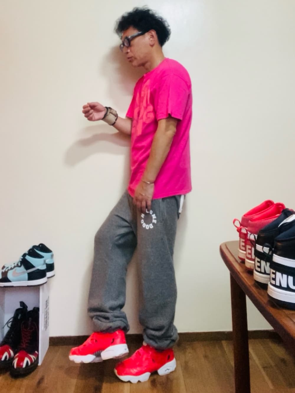 ピンク系のTシャツ/カットソー、グレー系のスウェットパンツ、ピンク系のスニーカーを着用したメンズの夏コーディネートの3枚目の写真