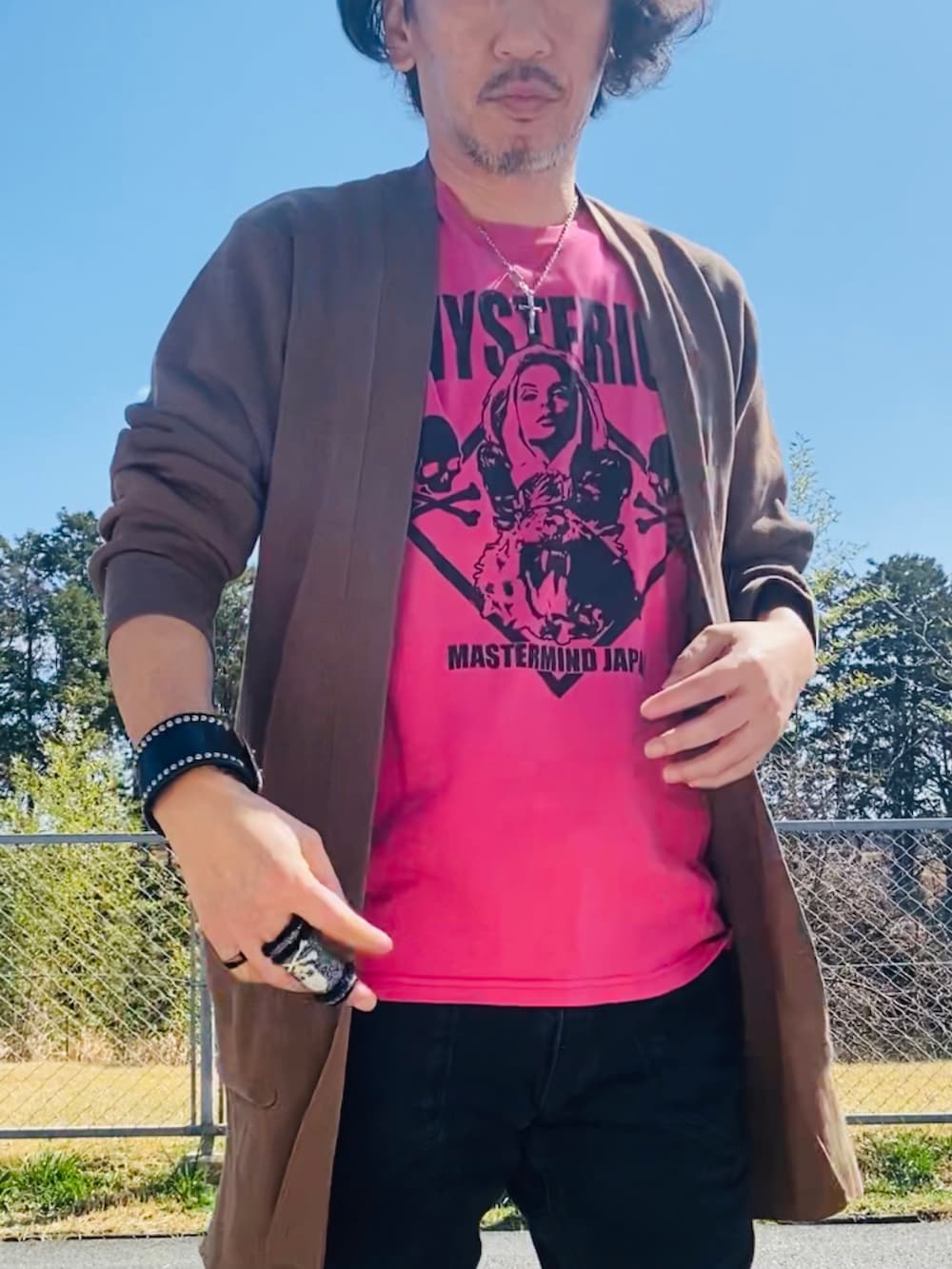 ピンク系のTシャツ/カットソー、ブラウン系のニット/セーター、ブラック系のデニムパンツを着用したメンズの春コーディネートの3枚目の写真