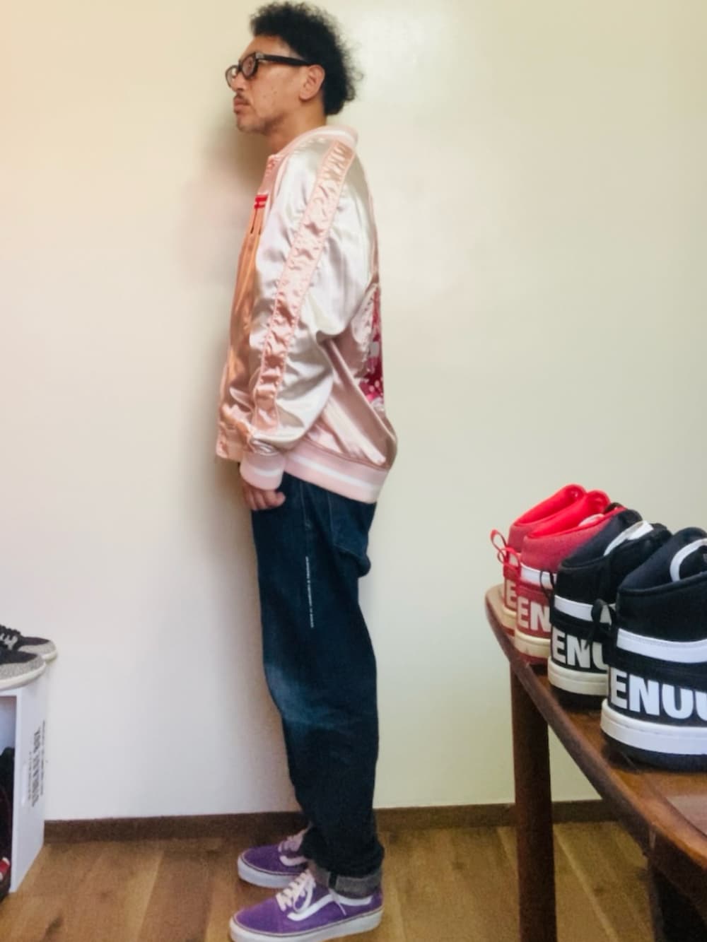 パープル系のスニーカー、ピンク系のスカジャン、ブルー系のデニムパンツを着用したメンズの秋コーディネートの4枚目の写真