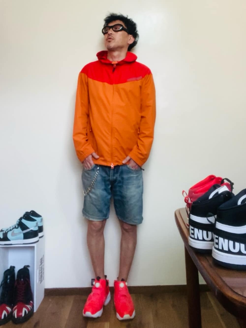 オレンジ系のマウンテンパーカー、ブルー系のその他パンツ、ピンク系のスニーカーを着用したメンズの春コーディネートの2枚目の写真