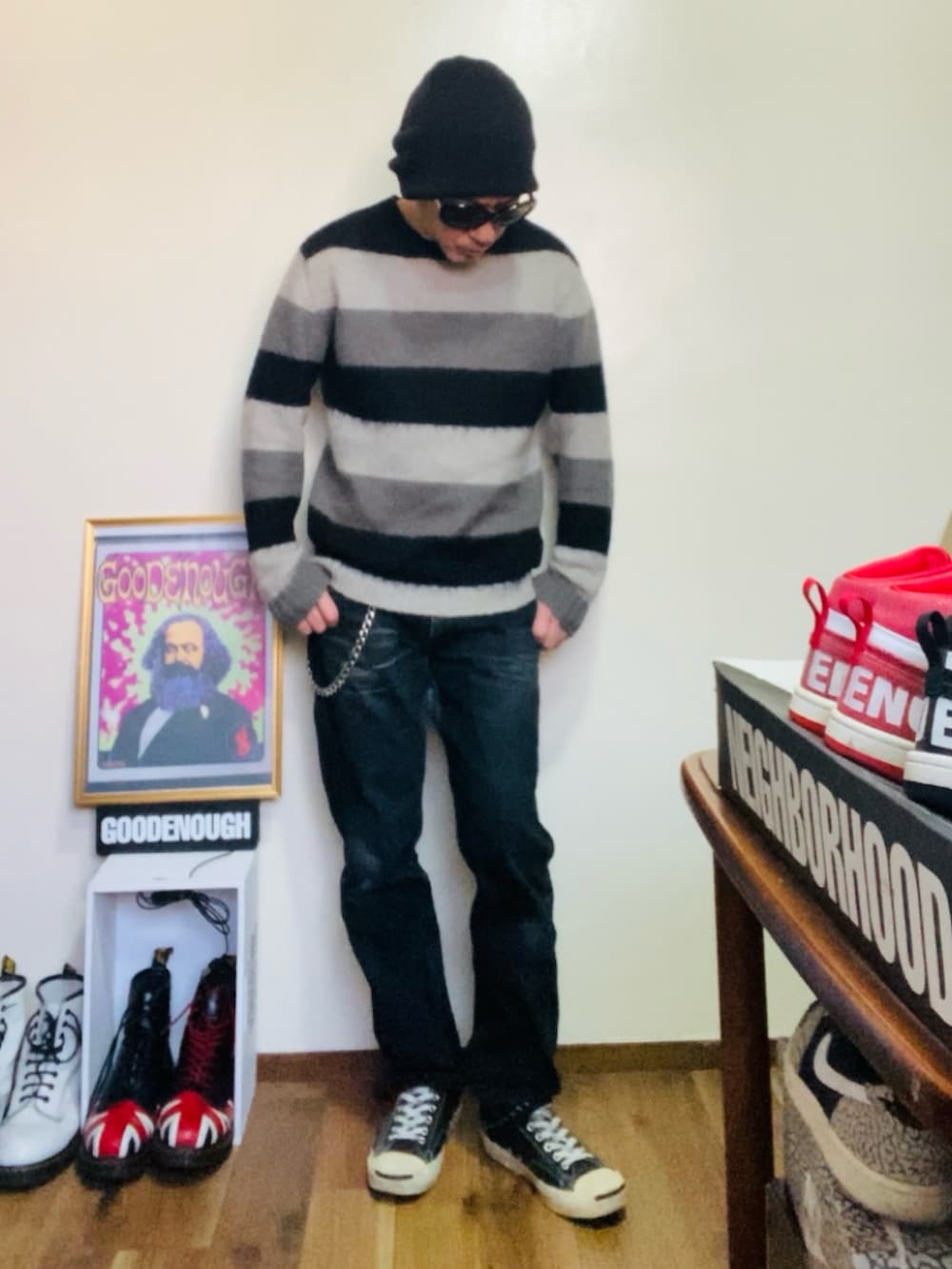 ブラック系のニット/セーター、ブラック系のデニムパンツ、ブラック系のスニーカーを着用したメンズの春コーディネートの4枚目の写真