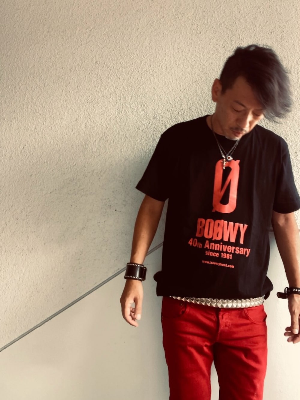 ブラック系のTシャツ/カットソー、レッド系のデニムパンツ、ホワイト系のベルトを着用したメンズの夏コーディネートの2枚目の写真