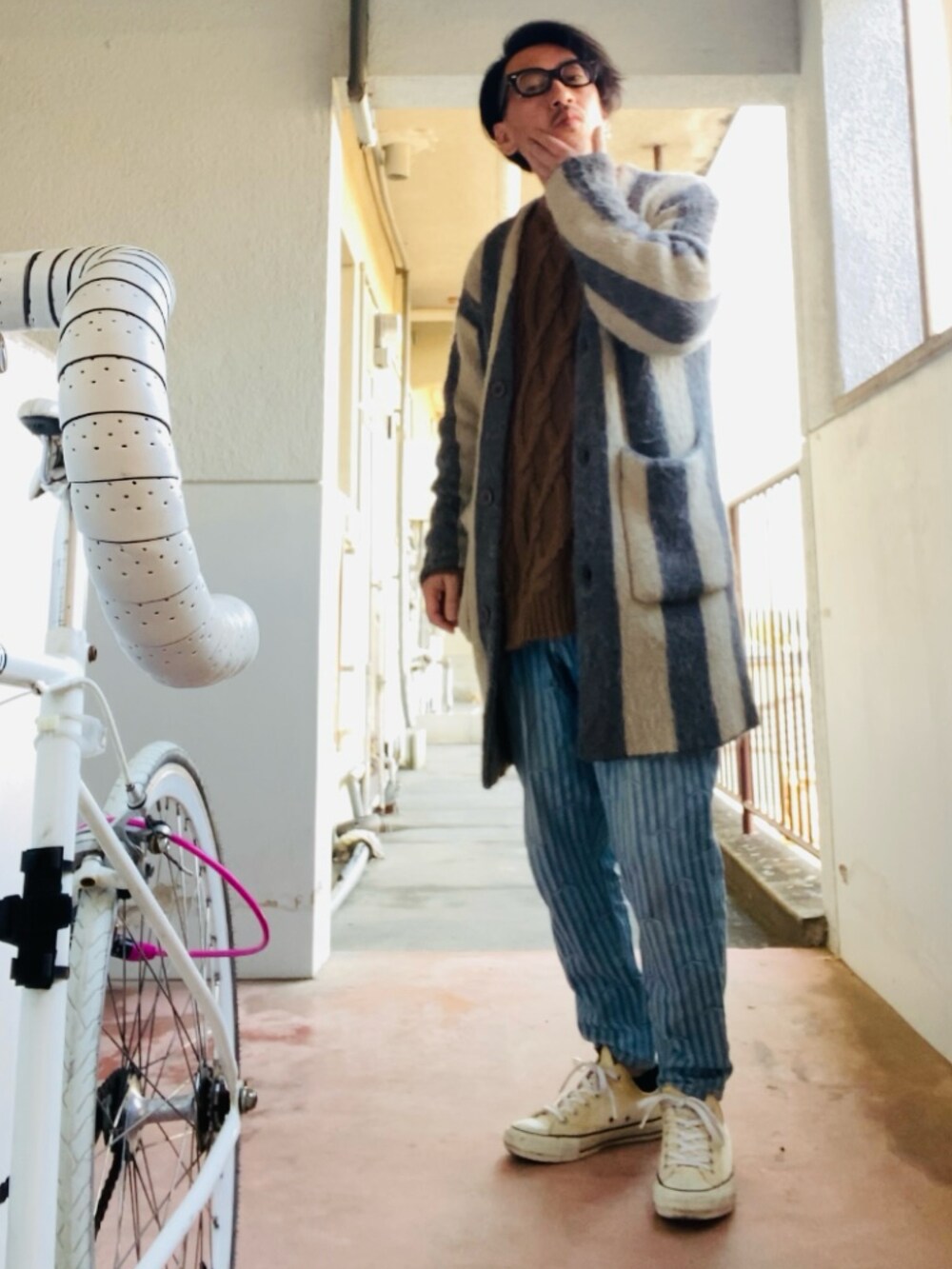 ブラウン系のニット/セーター、グレー系のカーディガン/ボレロ、ブルー系のデニムパンツを着用したメンズの春コーディネートの2枚目の写真