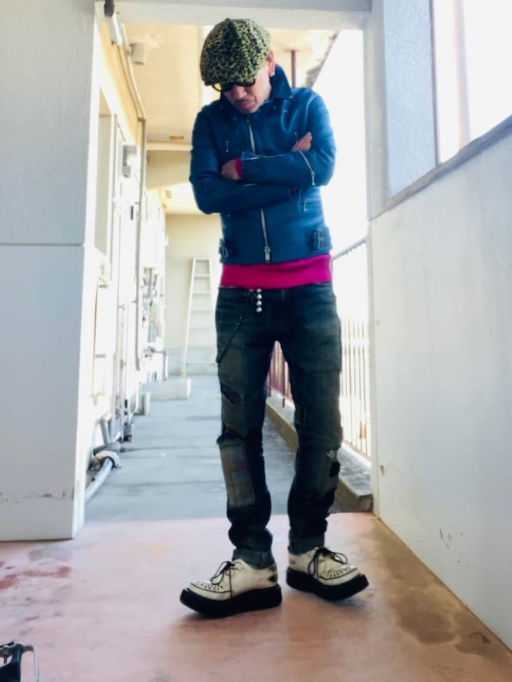 ブルー系のライダースジャケット、ピンク系のニット/セーター、ブルー系のデニムパンツを着用したメンズの冬コーディネートの3枚目の写真