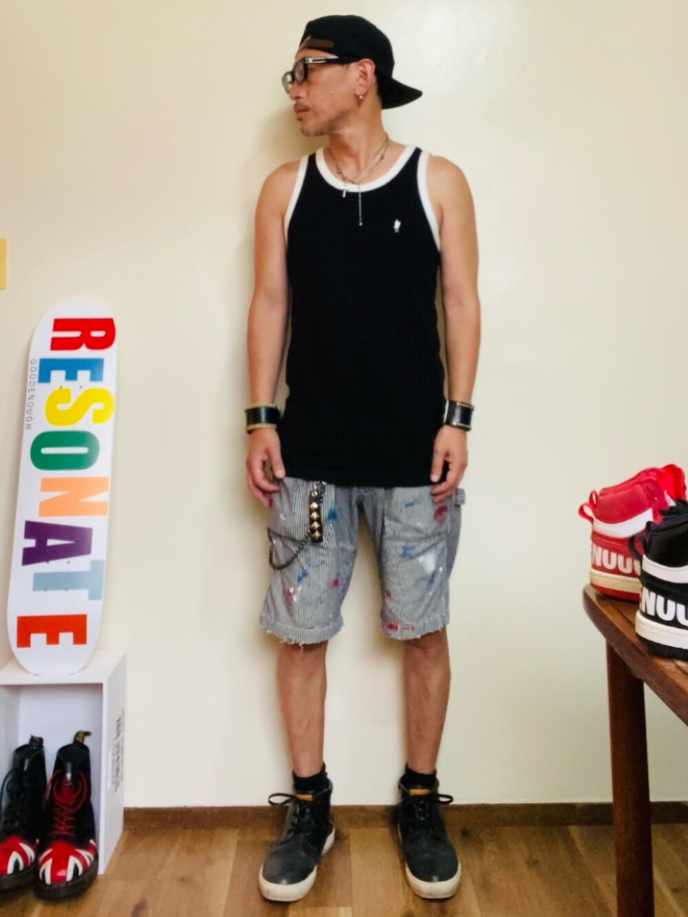 ブラック系のタンクトップ、グレー系のデニムパンツ、ブラック系のブーツを着用したメンズの夏コーディネートの2枚目の写真