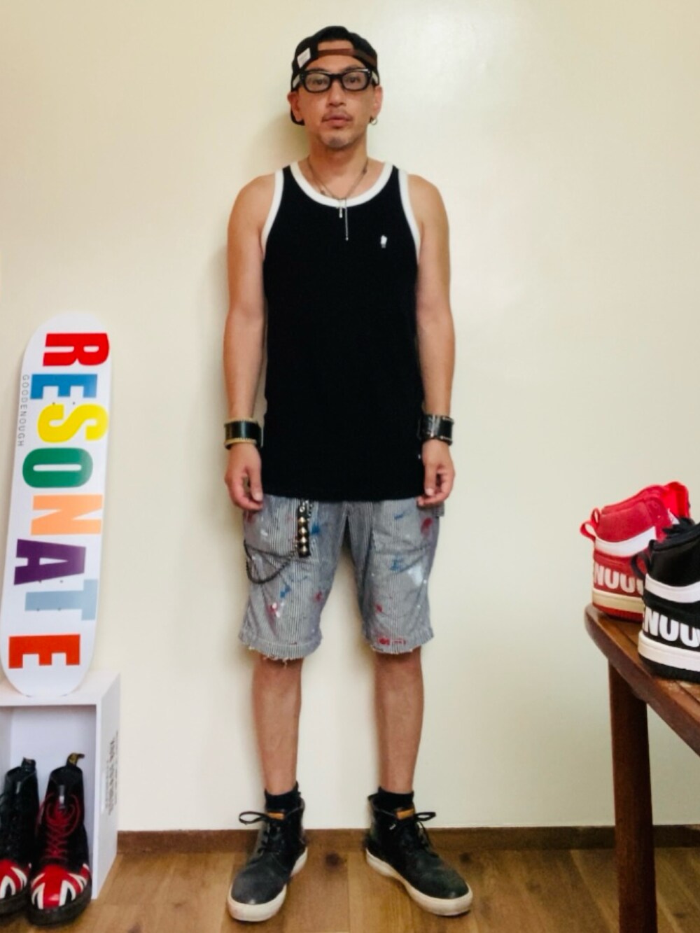 ブラック系のタンクトップ、グレー系のデニムパンツ、ブラック系のブーツを着用したメンズの夏コーディネートの3枚目の写真