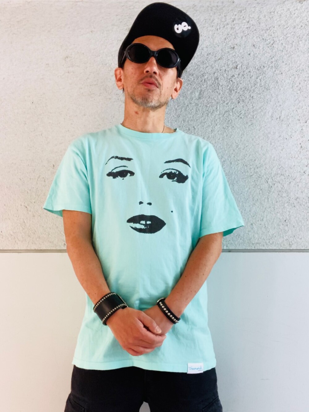 ブルー系のTシャツ/カットソー、ブラック系のカーゴパンツ、グリーン系のスニーカーを着用したメンズの春コーディネートの2枚目の写真