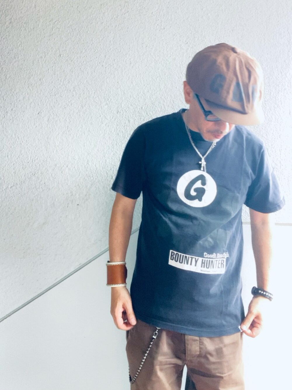 ブラウン系のチノパンツ、ブラック系のTシャツ/カットソー、ブラック系のスリッポンを着用したメンズの夏コーディネートの2枚目の写真