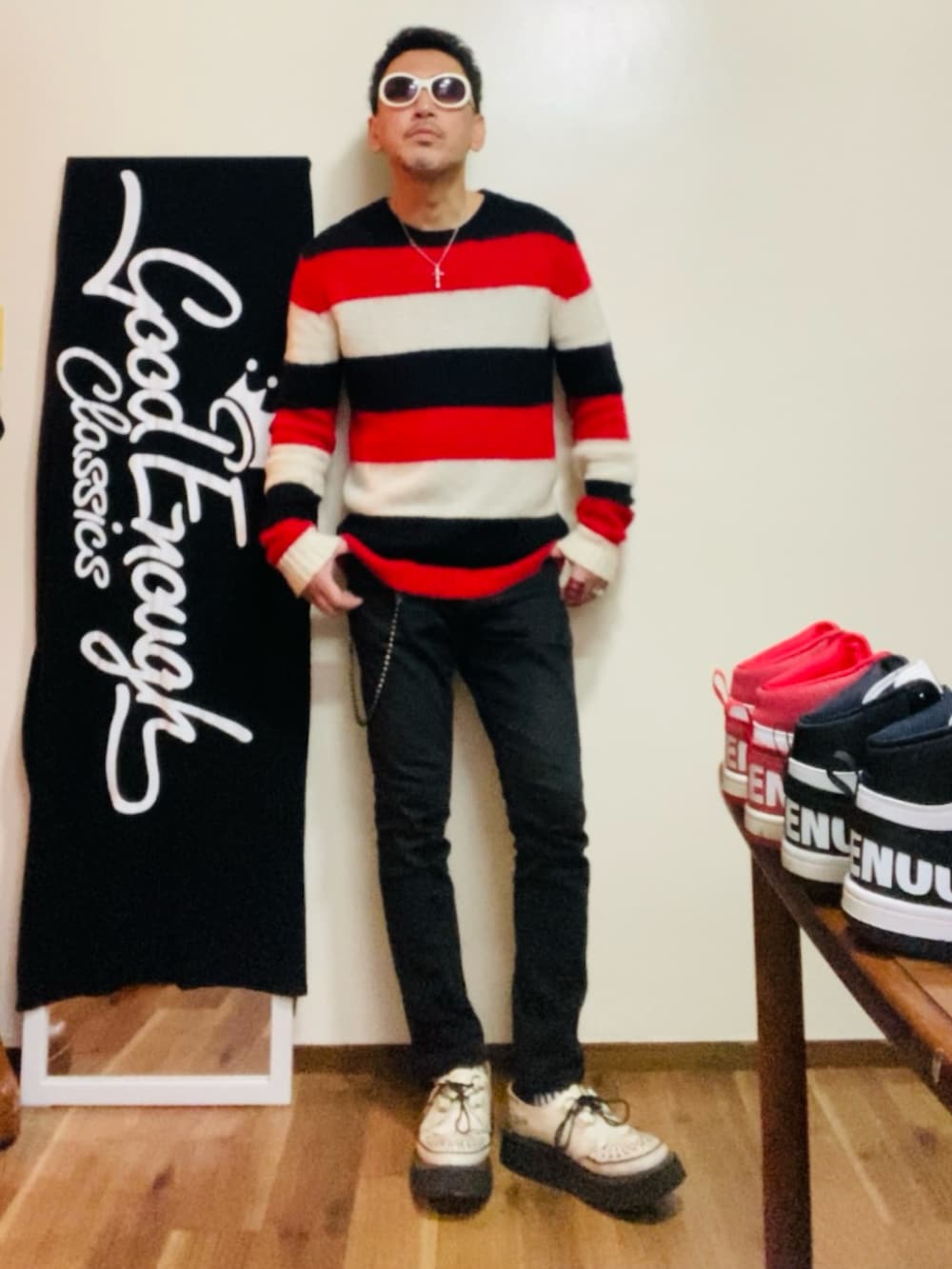 レッド系のニット/セーター、ブラック系のパンツ、ホワイト系のその他シューズを着用したメンズの冬コーディネートの2枚目の写真