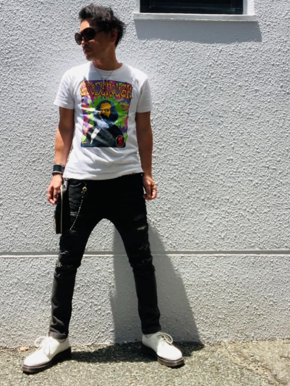 ホワイト系のTシャツ/カットソー、ブラック系のデニムパンツ、ブラック系のバッグを着用したメンズの夏コーディネートの4枚目の写真