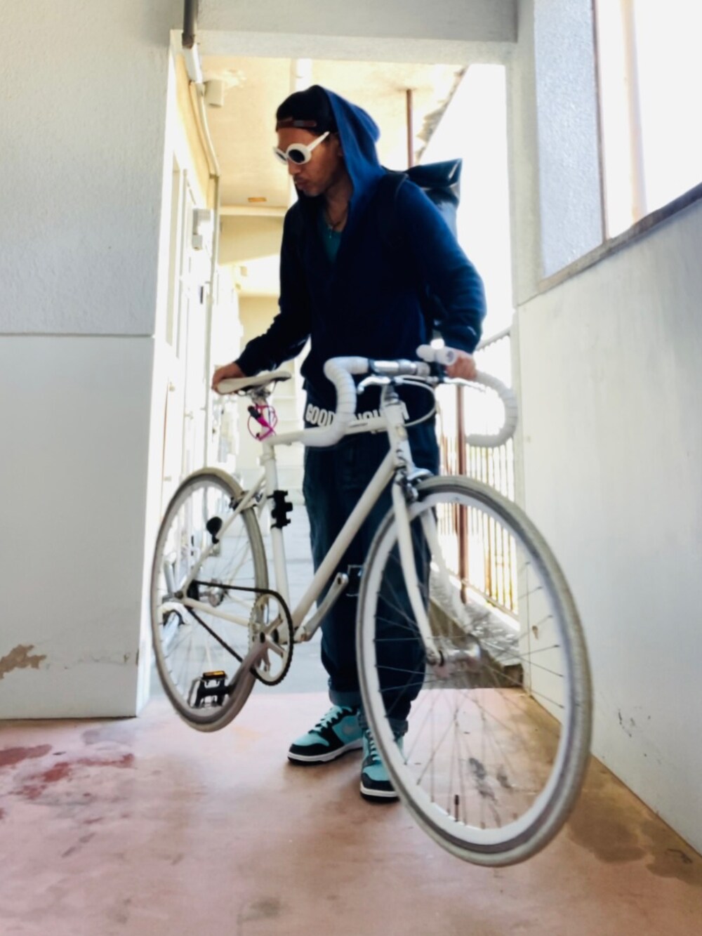 ブルー系のパーカー、ブルー系のデニムパンツ、ブラック系のバックパック/リュックを着用したメンズの秋コーディネートの5枚目の写真