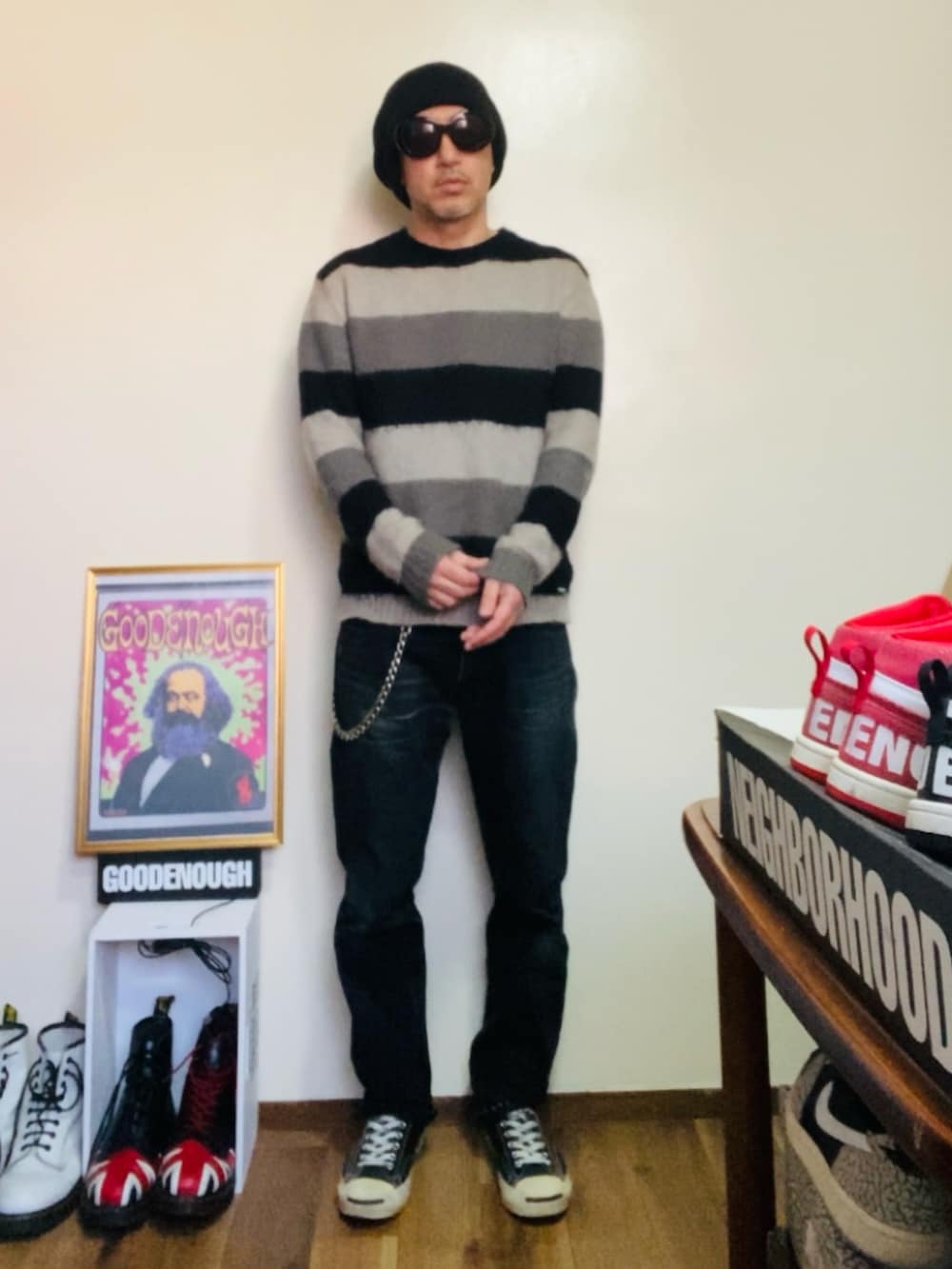 ブラック系のニット/セーター、ブラック系のデニムパンツ、ブラック系のスニーカーを着用したメンズの春コーディネートの2枚目の写真