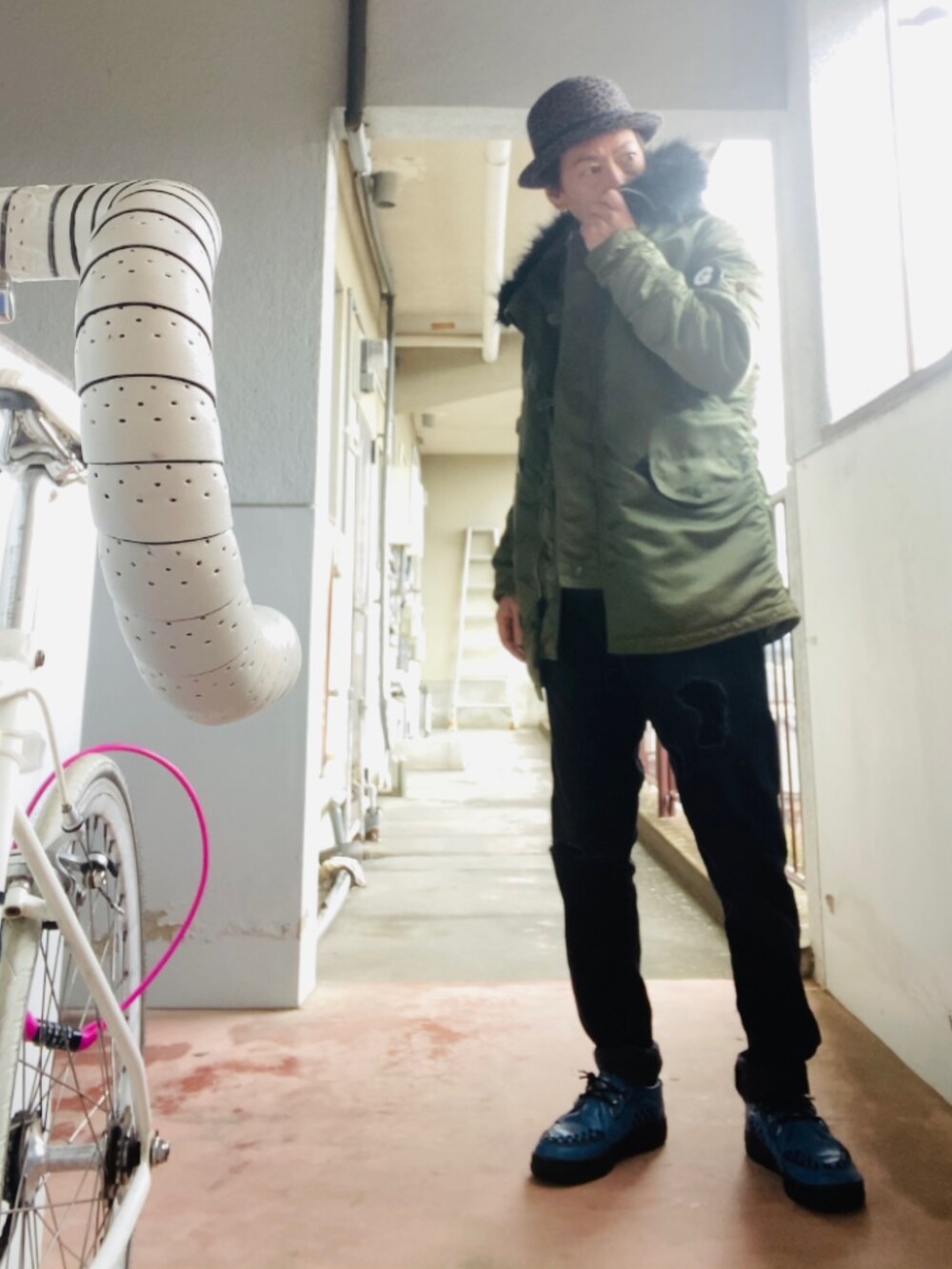 グリーン系のミリタリージャケット、グレー系のニット/セーター、ブラック系のその他パンツを着用したメンズの冬コーディネートの5枚目の写真