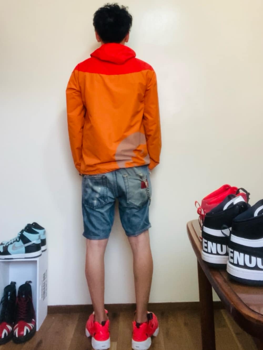 オレンジ系のマウンテンパーカー、ブルー系のその他パンツ、ピンク系のスニーカーを着用したメンズの春コーディネートの3枚目の写真