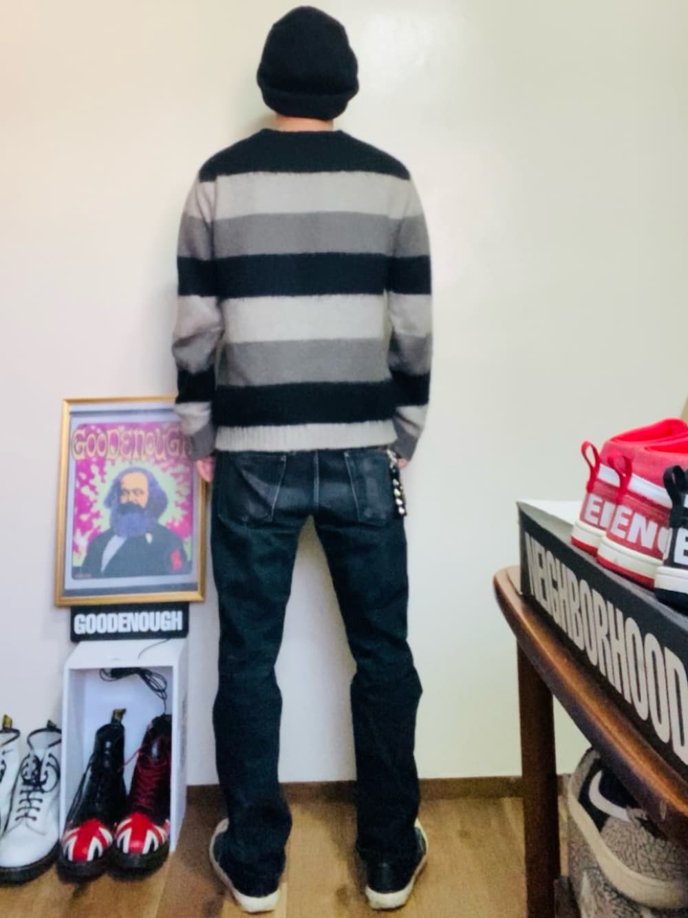 ブラック系のニット/セーター、ブラック系のデニムパンツ、ブラック系のスニーカーを着用したメンズの春コーディネートの3枚目の写真