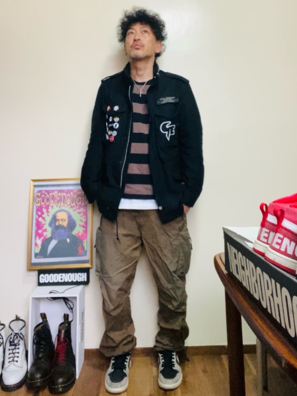 ブラック系のミリタリージャケット、ブラック系のTシャツ/カットソー、ブラウン系のカーゴパンツを着用したメンズの夏コーディネートの2枚目の写真